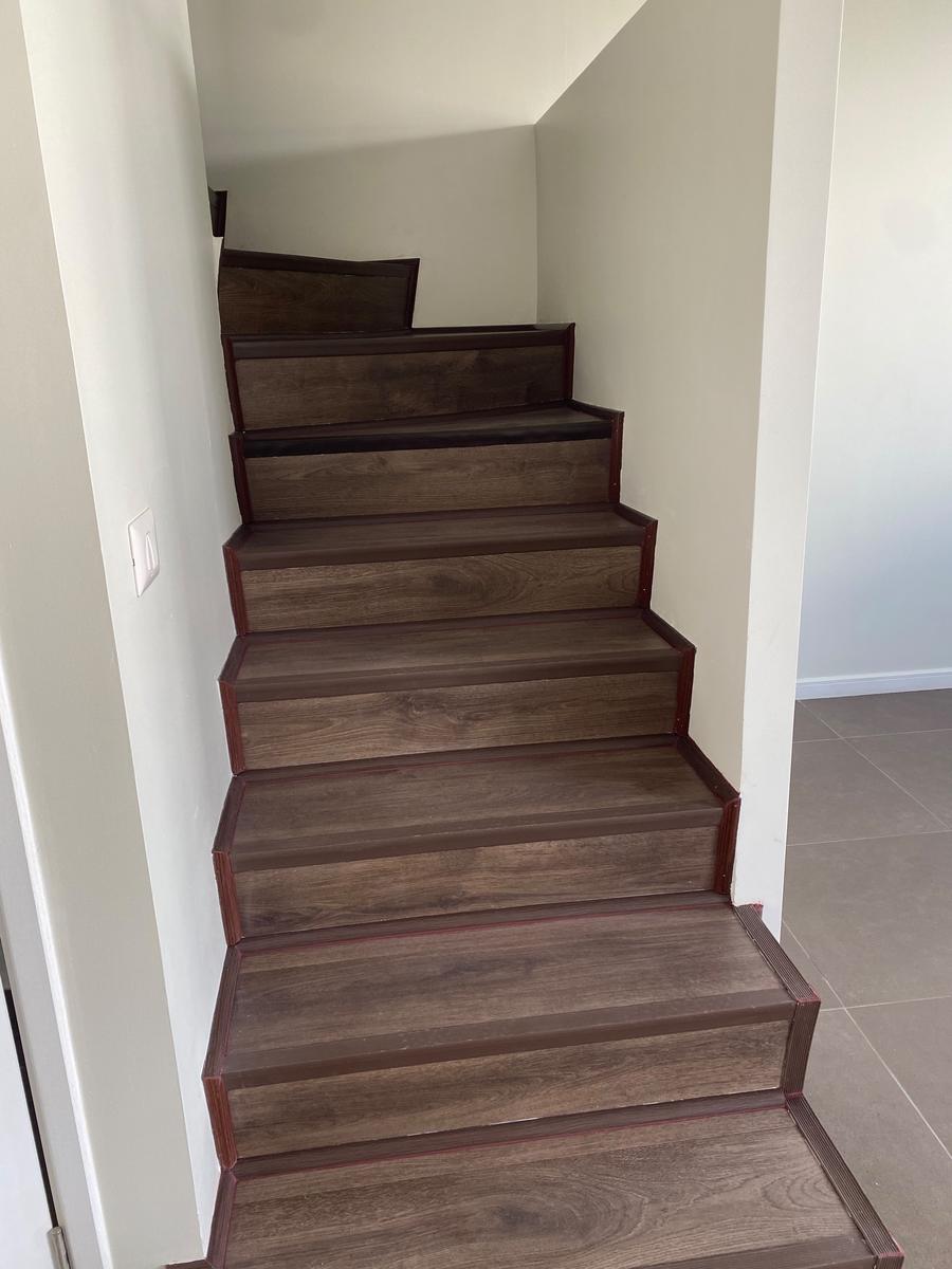 Escalera revestida con piso laminado y narices de peldaño